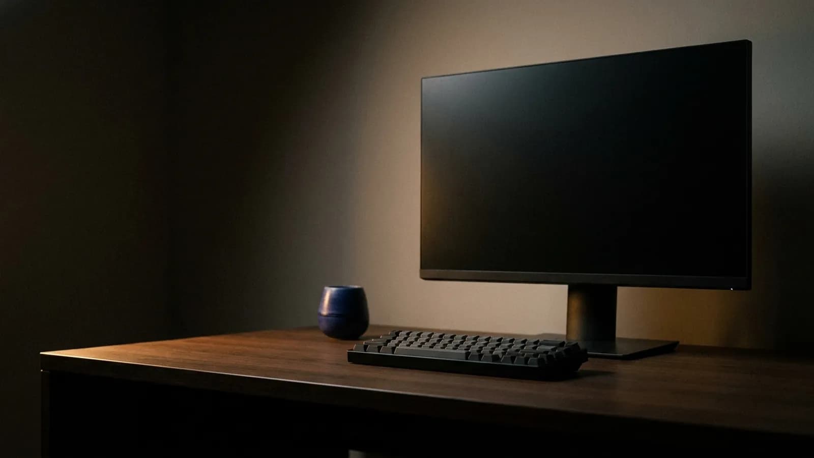 A dark desk setup lit by a single warm rim light