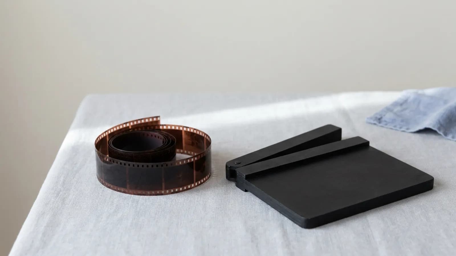 A strip of 35mm film beside a closed clapperboard