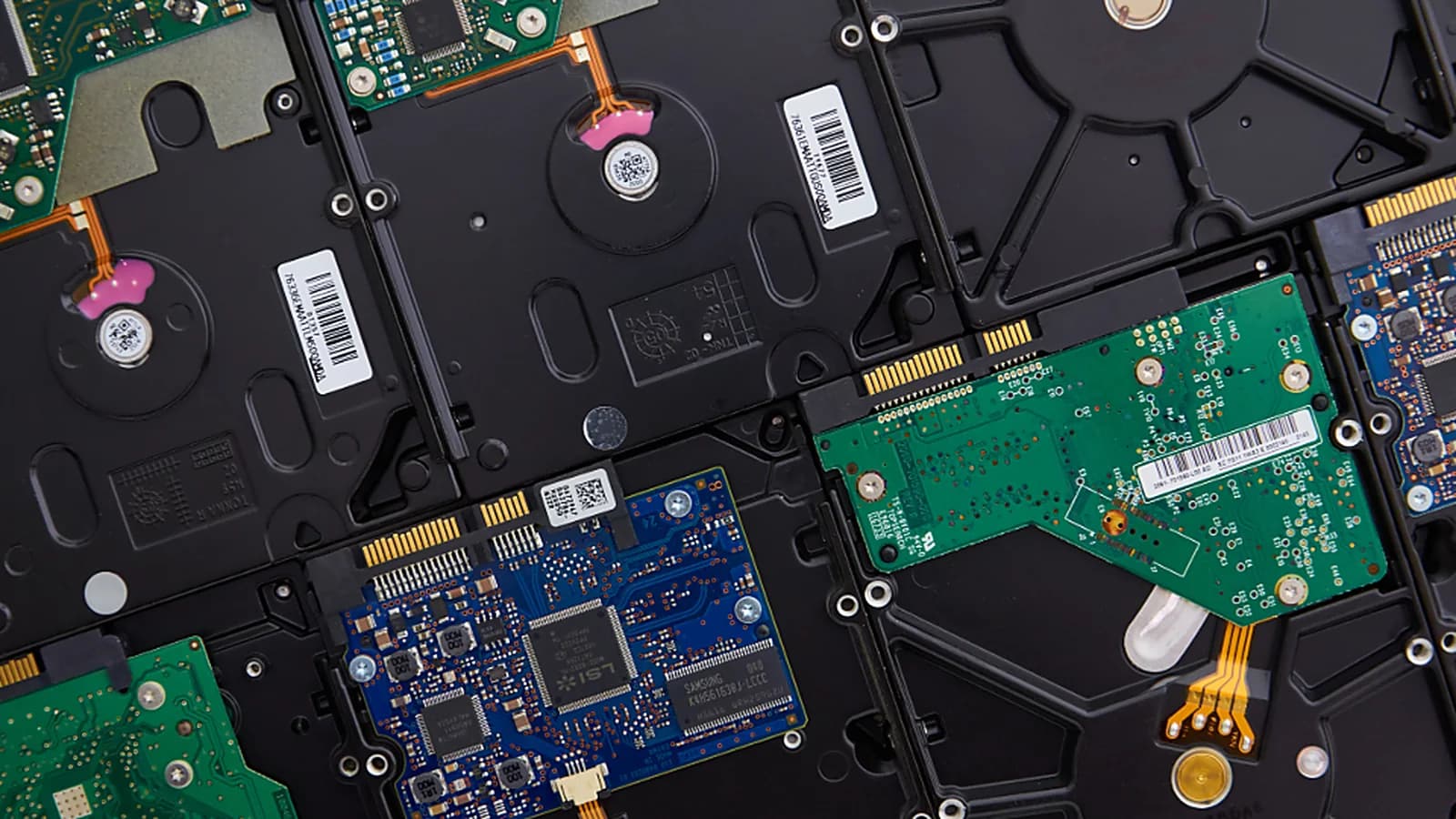 Photograph: a dozen bare hard drives laid face down and packed edge to edge, their green and blue controller boards and barcode labels showing